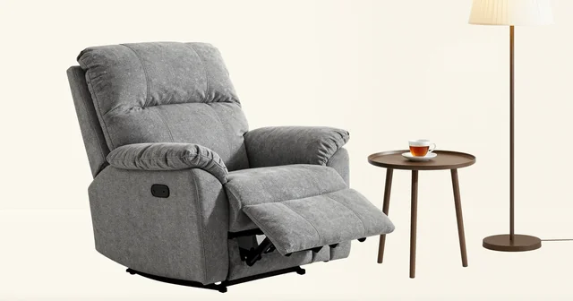 Illustration of a grey fabric recliner with its footrest up beside a side table and floor lamp