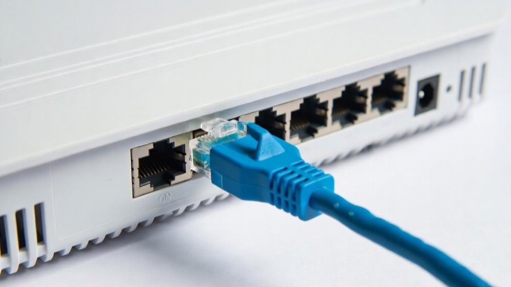 Ethernet cable plugged into a Wi-Fi router for a faster wired connection