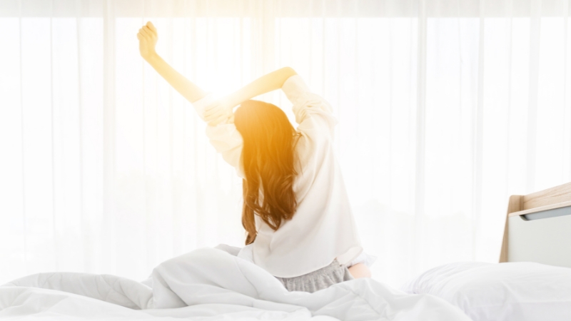 a lady doing morning stretches on bed