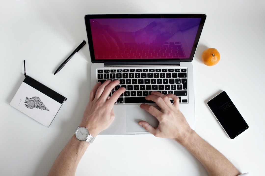 Computer on desk with person using laptop for RFP automation tools